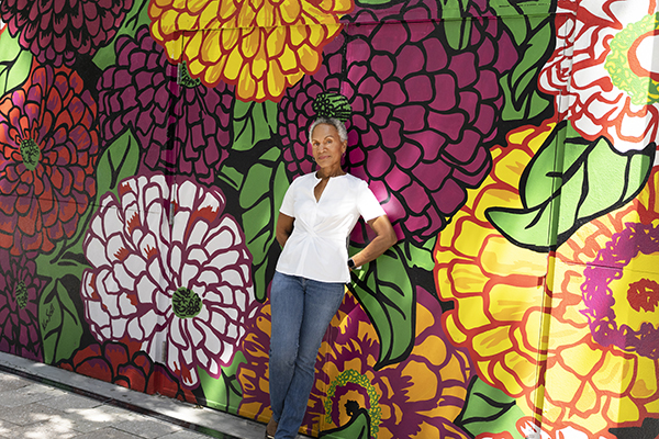 Clolita standing in front of a flower mural in the Miami Design District