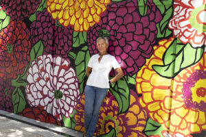 Clolita standing by a flower wall mural in the Design District in Miami